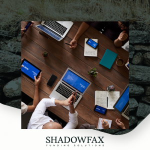 People meeting round a table with laptops and notebooks as seen from above